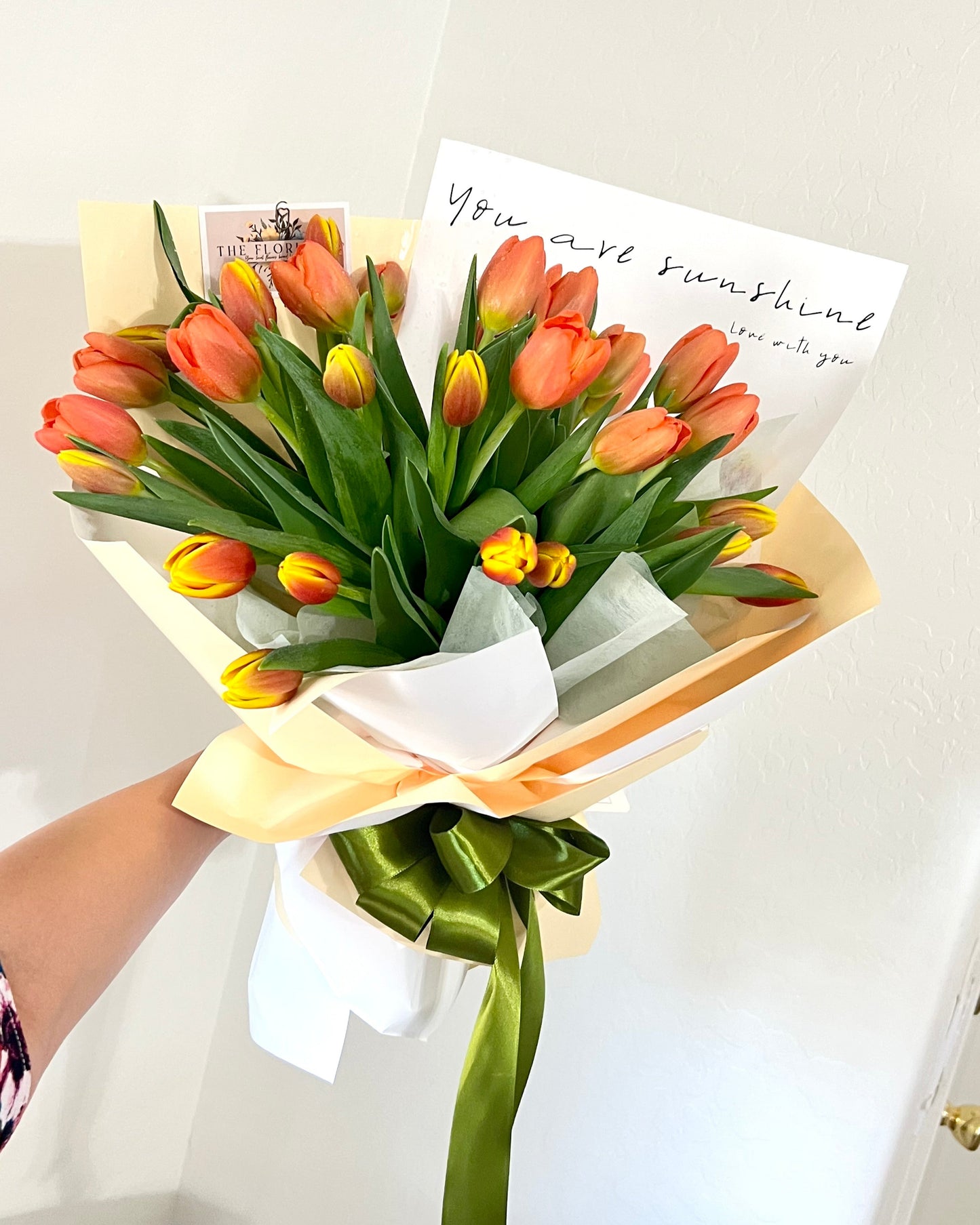 A vibrant bouquet of fresh tulips in mixed seasonal colors, wrapped in elegant paper, ready for same day flower delivery.