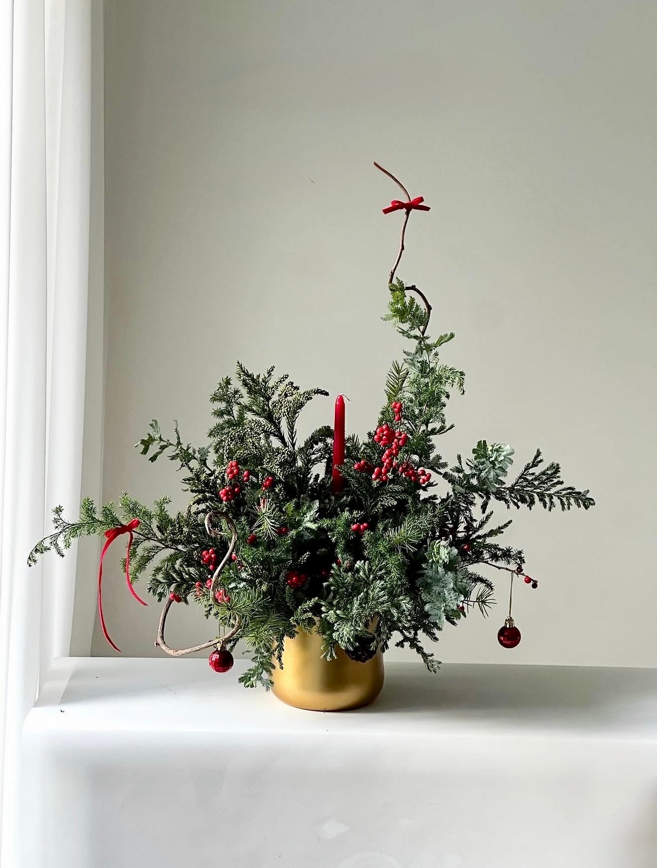 Handcrafted with premium winter greens, rich holiday elements, and subtle touches of sparkle, it creates a timeless, welcoming ambiance, perfect for dinner parties, family celebrations, or gifting.