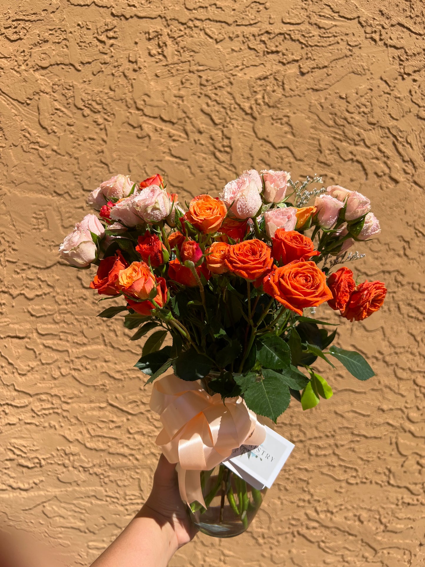Romantic orange spray roses bouquet in vase, perfect for celebrations or heartfelt gestures.