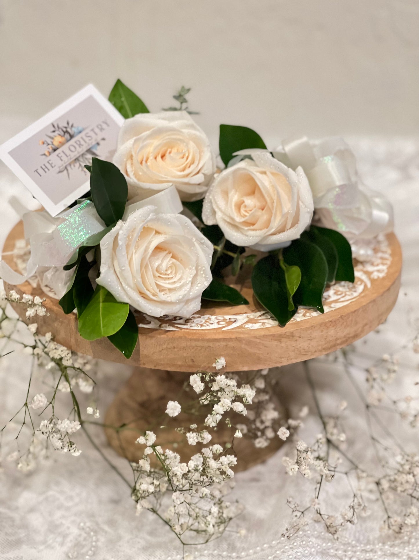 Fresh rose prom corsage with greenery and ribbon