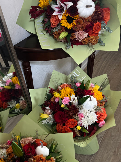 Stunning autumn flower arrangement with vibrant orange roses, deep red dahlias, golden sunflowers, and seasonal greenery, perfect for fall weddings, Thanksgiving centerpieces, and cozy home décor.