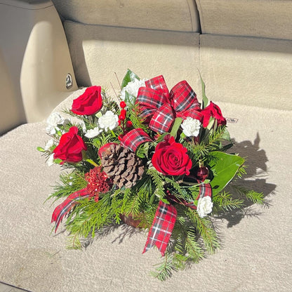 Mid size holiday centerpiece with fresh greenery, pinecones, berries, and apples in a red container. Perfect for festive tables or seasonal décor.

