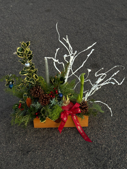 Decorative Christmas arrangement with greenery, pinecones, and a red ribbon on for delviery in Chandler, AZ.
