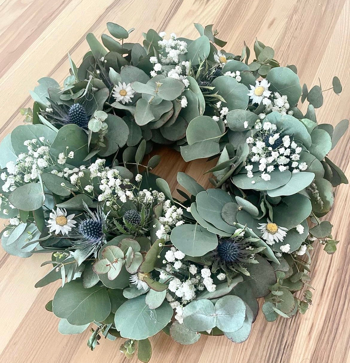 Fresh silver dollar eucalyptus centerpiece with soft greenery for table décor.
