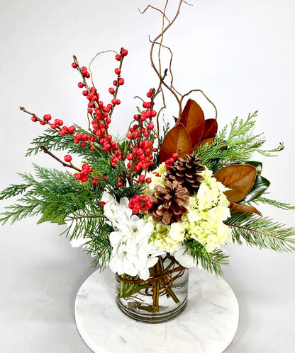  floral arrangement with roses, silvery eucalyptus, woody accents, and lush greenery in Standard, Deluxe, and Premium sizes.
