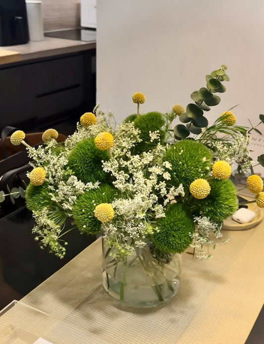 Vibrant First Day Bouquet featuring textured dianthus and sunny billy yellow balls. Available in deluxe and premium sizes. Perfect for brightening any space or gifting.
