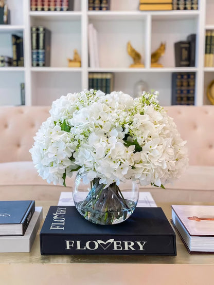 A large, fluffy white bouquet of flowers arranged in a clear glass vase. Same day flower delivery